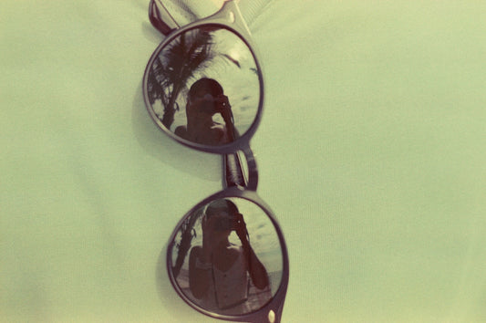 brown framed sunglasses on yellow textile