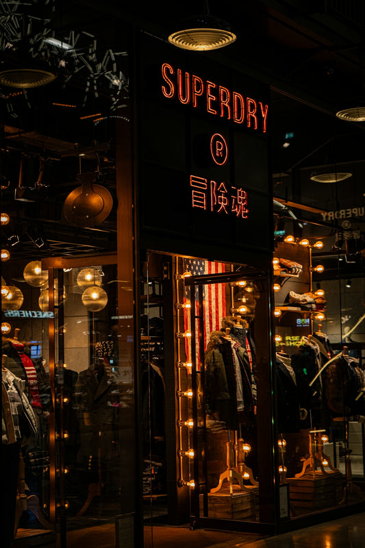 A clothing store with a neon sign in the window