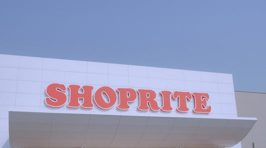 Shoprite sign on a building, beneath blue sky.